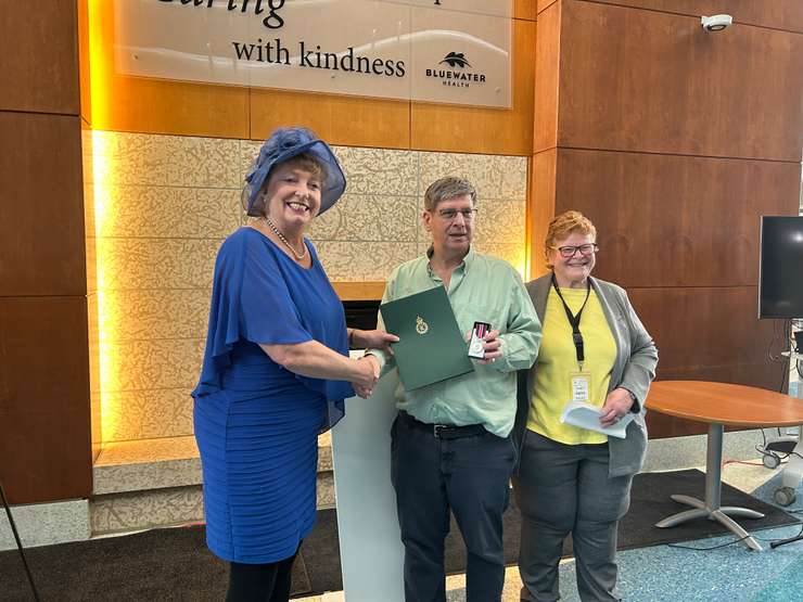 Sarnia-Lambton MP Marilyn Gladu (left) and Lynn LeFaive (right) of the Volunteer Coordinators' Association of Sarnia-Lambton present Rick McAlpine with a King Charles III Coronation Medal. February 27, 2025 at Bluewater Health. Blackburn Media photo by Lindsay Newman.