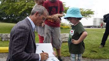 Chris Hadfield signs a copy of The Darkest Dark for four-year-old Bronzen Fontaine. August 6, 2019. (BlackburnNews photo by Colin Gowdy)