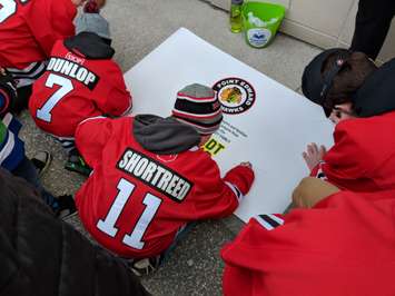 Minor hockey players signing a poster for Humboldt - Apr 9/18 (Blackburnnews.com Photo By Josh Boyce)