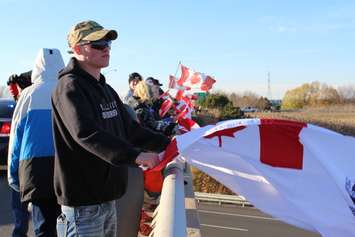Supporters come out to the Communications Rd. overpass on Hwy. 401 for the repatriation ceremony of fallen veteran and Wheatley native John Gallagher on November 20, 2015. (Photo by Ricardo Veneza)