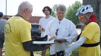 St. Clair Township Mayor Steve Arnold signs a book in support of injured workers. May 26, 2016 (BlackburnNews.com Photo by Briana Carnegie)