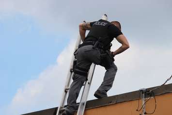 Police officers go on nearby rooftops searching for possible evidence, June 4, 2015. (Photo by Jason Viau)