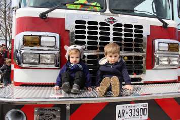 Emilio and Noah Wall relax on one of the Chatham Kent Fire and Emergency Services truck in Kingston Park on Monday. (photo by Michael Hugall)