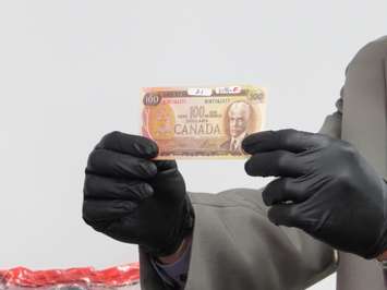 File photo of a counterfeit $100 bill seized by police in London. (Photo by Miranda Chant, Blackburn News)
