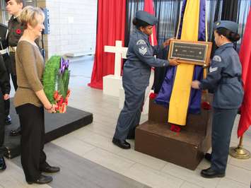 A plaque is hung at St. Joseph's High School in Windsor, honouring Cpl. Andrew Grenon. His mother Theresa Charbonneau stands to watch (left). November 11, 2014. (photo by Mike Vlasveld) 