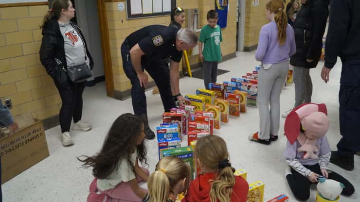 Deputy Fire Chief Rick MacGregor helping students line up cereal boxes. April 30, 2026. (Photo by Natalia Vega)