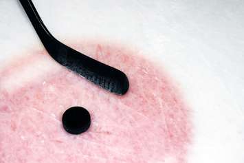 Hockey sport background: graphite stick and puck on real arena used and scratched ice.© Can Stock Photo / Mirage3