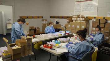 Medical workers drawing up doses of COVID vaccines at the Point Edward Arena vaccination clinic. 26 March 2021. (BlackburnNews.com photo by Colin Gowdy)