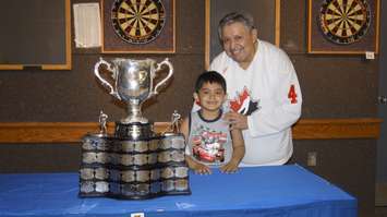 Memorial Cup on display at Sarnia Legion. (Left to right) Mark George Jr. and his dad, Mark A. George Sr., have their photo taken with the cup. May 18, 2017 (Photo by Melanie Irwin)