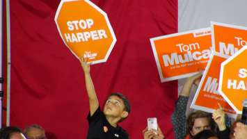A boy holds up a sign during NDP Leader Tom Mulcair's visit to the Town of Essex, October 4, 2015. (Photo by Jake Kislinsky)