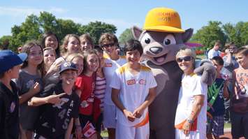 Mascot Pachi the porcupine poses with torchbearer Nathan Oliphant and elementary students at ASW track. June 16, 2015 (BlackburnNews.com Photo by Briana Carnegie)