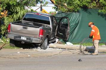 A truck knocks down two hydro poles and smashes through a fence on Drouillard just north of Franklin St., June 10, 2015. (Photo by Jason Viau)