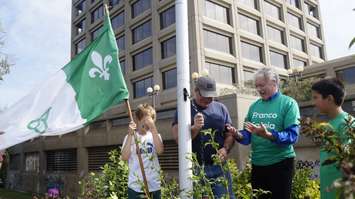 Mayor Mike Bradley looks at his hands after helping raise the Franco-Ontarian flag at the Seaway Parkette in Sarnia. September 25, 2019. (BlackburnNews photo by Colin Gowdy)