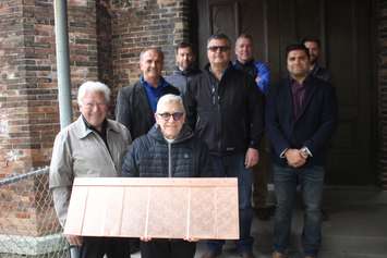 Paul Mullins, left, and Father Maurice Restivo show off one of the copper shingles that will be used in the restoration of historic Assumption Church, May 10, 2019. Photo by Mark Brown/Blackburn News.