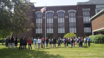 Students and staff gather for a symbolic lowering of the flag at the former SCITS high school on Wellington Street. June 19, 2019 Photo by Melanie Irwin