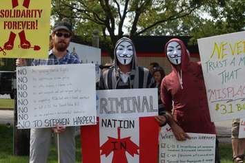 Protesters rally outside of Windsor's Anchor Danly for a campaign stop by Conservative Leader Stephen Harper on September 20, 2015. (Photo by Ricardo Veneza)