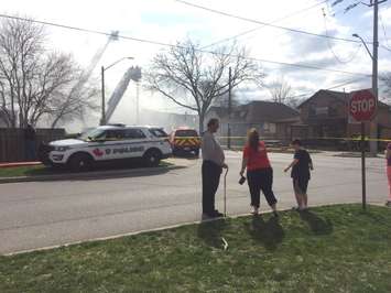 Residents look on as firefighters battle a blaze on Sandwich St. near Chippawa St. in Windsor, April 11, 2017. (Photo by Maureen Revait)