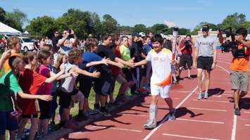 Torchbearer Nathan Oliphant high-fives former friends at Sarnia Pan Am torch run June 16, 2015 (BlackburnNews.com Photo by Briana Carnegie)