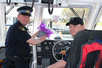 OPP officers displaying a purple ribbon in a boat at Sarnia Bay Marina (Photo by Terry Easterby)