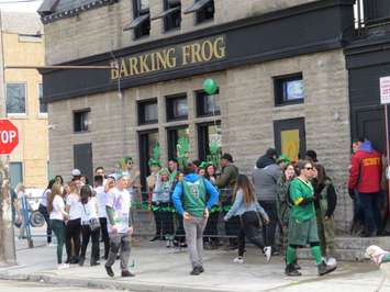 A group of St. Patrick's Day revellers lined up outside of The Barking Frog on Richmond Row, March 17, 2017. (Photo by Miranda Chant, Blackburn News.)