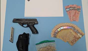 Cash, a weapon, and suspected fentanyl are displayed on October 8, 2025. Photo courtesy Windsor police.