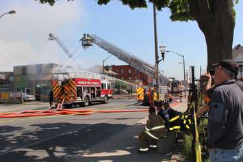 Residents watch and take pictures as firefighters battle the blaze on Wyandotte St. E in Windsor, May 23, 2016.  (Photo by Adelle Loiselle)