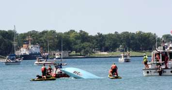 Crews come to the aid of an overturned powerboat in racing August 9, 2015 (BlackburnNews.com photo by Dave Dentinger)