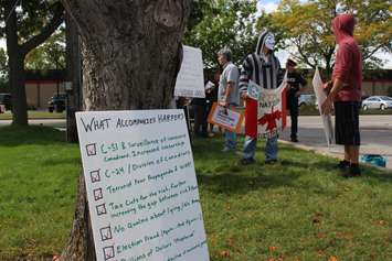 Protesters rally outside of Windsor's Anchor Danly for a campaign stop by Conservative Leader Stephen Harper on September 20, 2015. (Photo by Ricardo Veneza)