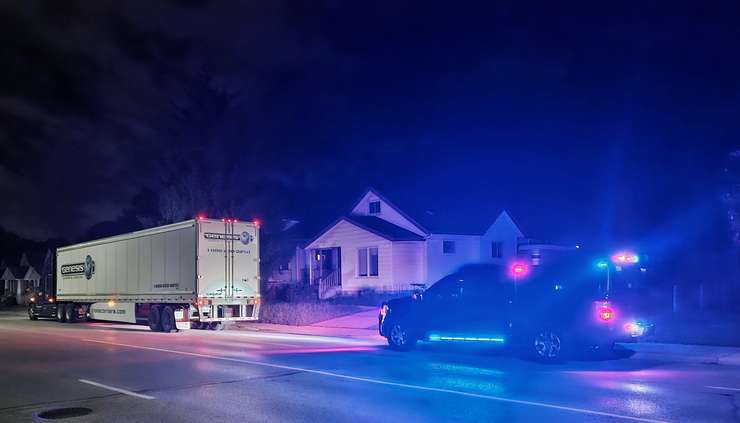 A Sarnia Police officer pulls over a large commercial vehicle illegally cutting through the city. July 2023. (Photo by Sarnia Police Service)