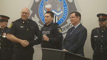 Sarnia Police Chief Derek Davis (left) and Police Board Chair Paul Wiersma (right) pose for picture with new police constable Joshua Bayne. 6 April 2023. (Photo by SarniaNewsToday.ca)