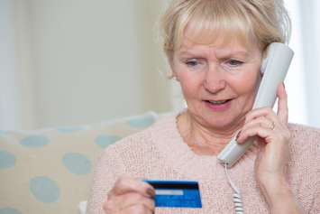 Senior woman giving credit card details on the phone. © Can Stock Photo / daisydaisy