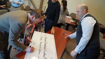 Vice President of NGL Supply Co. Ltd. David Palmer signs the sponsorship cheque of $20,000 for Bluewater International Granfondo. March 4, 2016 (BlackburnNews.com Photo by Briana Carnegie)