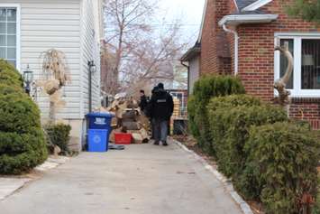 Windsor police officers canvass the neighbourhood surrounding 1566 Benjamin Ave. as a death investigation continues, December 11, 2014. (photo by Mike Vlasveld)