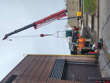 Workers use a crane outside Sarnia Police headquarters. 4 April 2023. (Photo by Melanie Irwin)