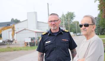 Strathroy-Caradoc Fire Chief Steve Beasley and retired firefighter Bob Fortner gather as the former firehall is demolished behind them. September, 2025. Photo courtesy of the Municipality of Strathroy-Caradoc.