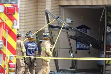 Three people were sent to hospital after a car smashes through the front of an RBC Bank on Huron Church Rd., July 3, 2015. (Photo by Jason Viau)