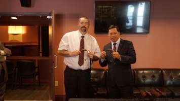 Economic Development and Infrastructure Minister Brad Duguid and local deaf resident show off hearing tools for viewing Imperial Theatre plays May 29, 2015 (BlackburnNews.com Photo by Briana Carnegie).
