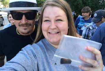 Fan Amanda Haskell shows off the remains of cigar smoked by Kid Rock, who stands behind her during the RM Sotheby's 40th Anniversary parade, June 21, 2019.  (Photo courtesy of Amanda Haskell)