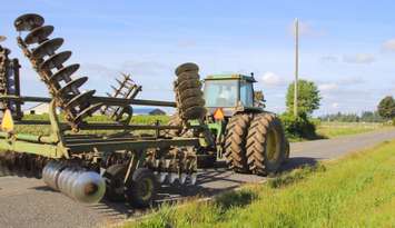 Farm equipment moving on rural road (Image courtesy of Getty Images/Modfos)