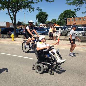 Aaron Jubenville carries the Pan Am Games torch to a celebration in Wallaceburg June 16, 2015. (Photo by Simon Crouch) 