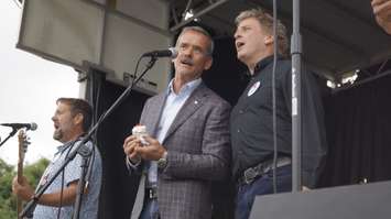 Chris Hadfield holds a birthday cupcake and sings alongside The Arrogant Worms at Canada’s Walk of Fame Hometown Star Celebration. August 6, 2019. (BlackburnNews photo by Colin Gowdy)