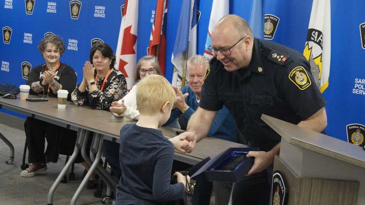 SPS Chief Derek Davis gives six-year-old Benny Canie a plaque. April 23, 2024. (Photo by Natalia Vega)