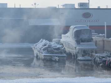 Ice encases boats and ATVs after firefighters battling a massive fire at Hully Gully soak the area with water, December 28, 2017. (Photo by Miranda Chant, Blackburn News)