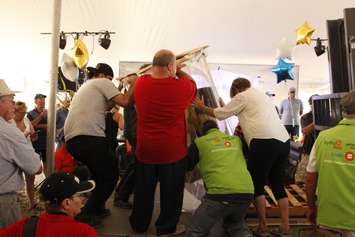 A team of volunteers sets the huge glass for the World Records attempt on the stage at the International Plowing Match, September 19, 2018. (Photo by Angelica Haggert)