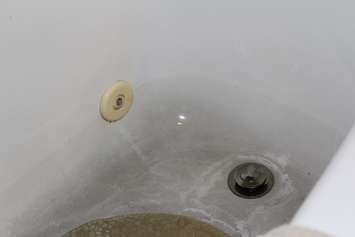 Remains of black sediment in a bathtub near Dover Township, which local activists claim was caused by wind turbine construction, July 15, 2016 (Photo by Jake Kislinsky)
