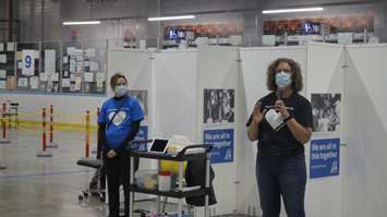 Bluewater Health's Nadine Neve (left) and Lambton Public Health's Anita Trusler (right) give a tour of the Point Edward Arena vaccination clinic. 26 March 2021. (BlackburnNews.com photo by Colin Gowdy)