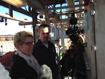 Kathleen Wynne prepared to push the button to empty tomato wagons at Highbury Canco. October 16, 2015 (Photo by Kevin Black)