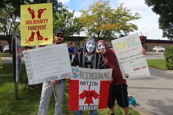 Protesters rally outside of Windsor's Anchor Danly for a campaign stop by Conservative Leader Stephen Harper on September 20, 2015. (Photo by Ricardo Veneza)