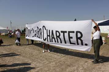 A small handful of protesters came from Toronto to protest Ontario Premier Doug Ford. Their sign reads ``Don`t plow our charter.`` (Photo by Angelica Haggert)