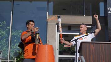 Wes Harding holds the first torch high at Sarnia Pan Am Games celebration outside City Hall June 16, 2015 (BlackburnNews.com Photo by Briana Carnegie)